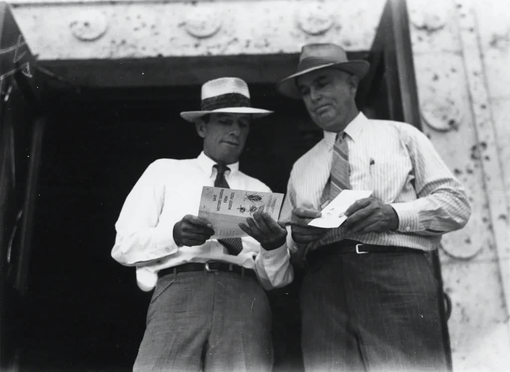 Travis County Extension agents reading insect brochures, undated. -Photo No. PICA 12789, Austin History Center, Austin Public Library